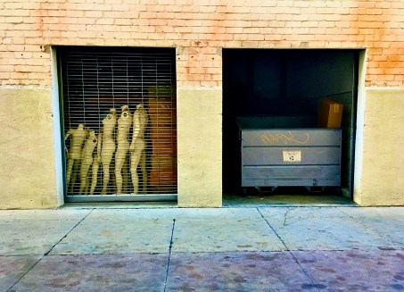 dumpster and mannequins in alley